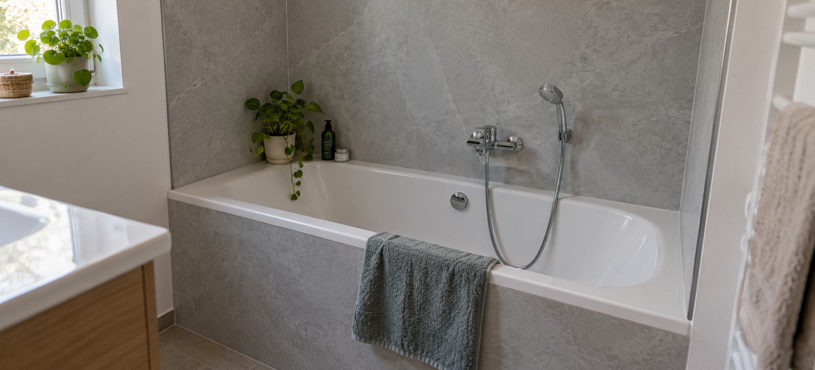 Badewanne mit Wandverkleidung aus Aluverbundplatten in grauer Steinoptik statt Fliesen – Deutsche Kunststoffbedachungen