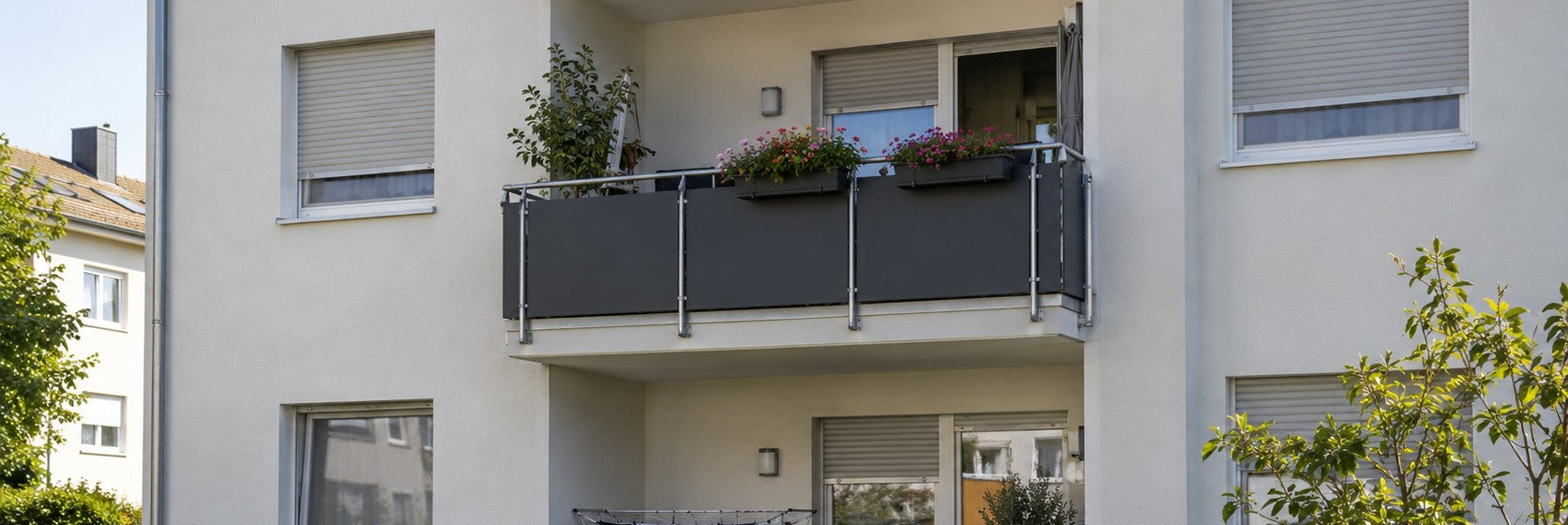 Balkonbrüstungen mit HPL-Platten in Anthrazit statt Blech an einem Mehrfamilienhaus – Deutsche Kunststoffbedachungen