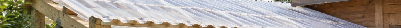 Holzunterstand mit Brennholz, dessen Pultdach mit milchigen Polyesterwellbahnen gedeckt ist – Deutsche Kunststoffbedachungen