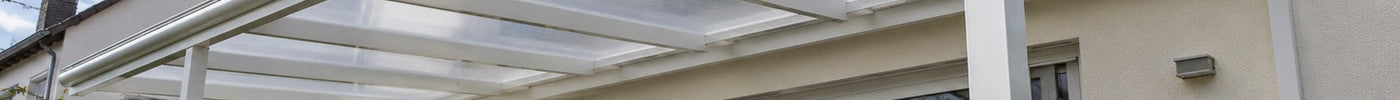 Terrassendach mit klaren Polycarbonat-Stegplatten auf weißer Alu-Konstruktion am Reihenhaus – Deutsche Kunststoffbedachungen